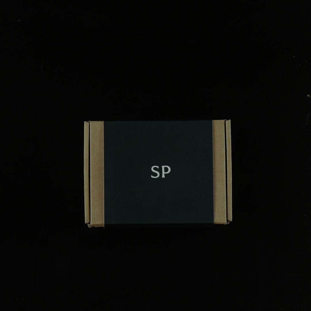Load video: Black Sculpted Peaks gift box being unboxed, with the welcome card, stone and wood samples and design booklet