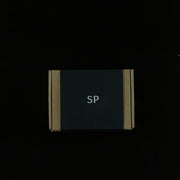 Black Sculpted Peaks gift box being unboxed, with the welcome card, stone and wood samples and design booklet