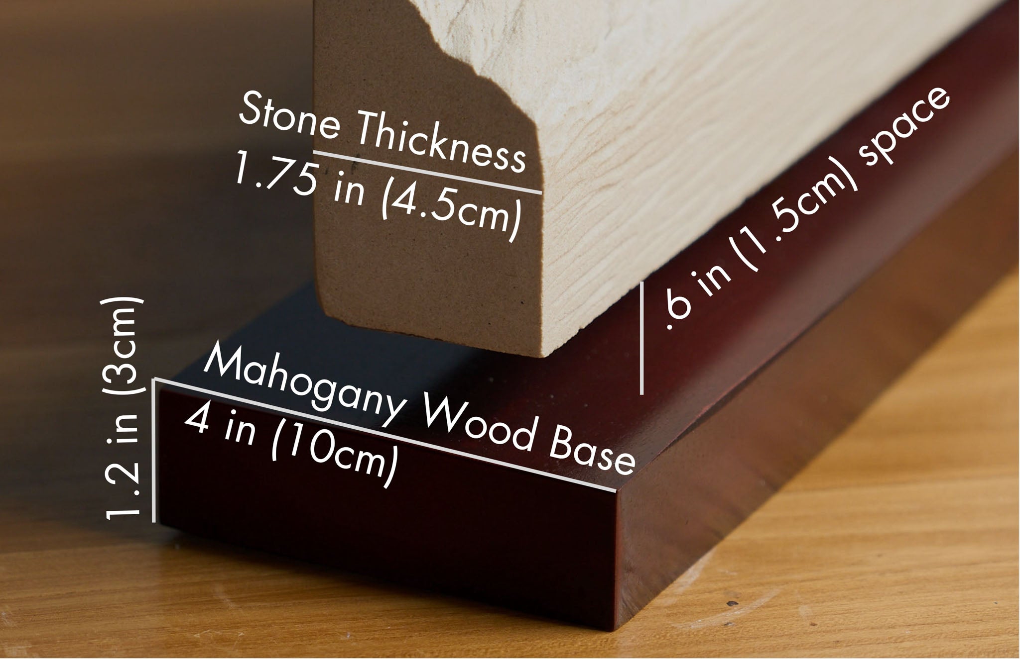 Close-up of a mahogany wood base and stone sculpture, displaying measurements for stone thickness, base height, and spacing.